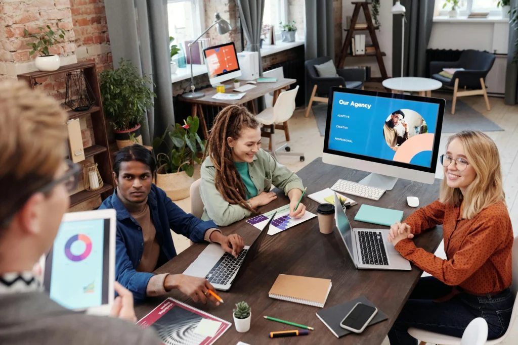 Digital marketing agency team UK discussing web design, branding and SEO strategy during a collaborative office meeting.