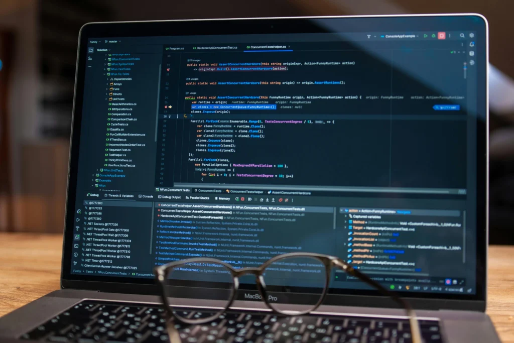 Laptop screen displaying custom software development code and debugging tools, representing professional web and application development services.